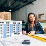 Smiling African American Woman Taking Notes Near Model Building